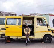 DJ Evans Mireku Kissi pozuoja prie mikroautobuso