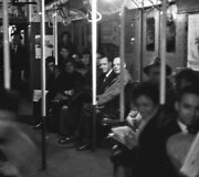 Keliautojai pritemusiame metro vagone