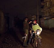 Policininkas tikrina dokumentus per naktinį reidą