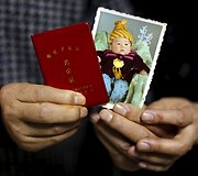 Zhang Yinxiu rodo sūnaus nuotrauką su jo garbinguoju vienintelio vaiko sertifikatu