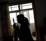 Huang Peiyao savo namuose, apkabinusi sūnaus nuotrauką
