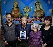 Jiangas Weimao'as su žmona Zhang Yinxiu, tarp jų Zhang tėvai, kurie laiko žuvusio sūnaus nuotrauką