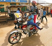 Jaunuoliai, važiuojantys motociklu Centrinės Afrikos Respublikos gatvelėmis