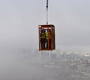 Žurnalistai narve apžiūri Frankfurto statybas i&scaron; oro