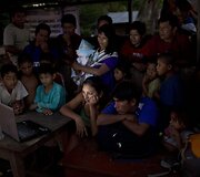 Bendruomenė žiūri sveikatos apsaugos darbuotojų pateiktą mokomąjį filmą apie visavertę mitybą, 