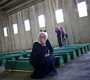 Moteris verkia prie naujai atpažintų Srebrenicos žudynių aukų kūnų Bosnijoje ir Hercegovinoje