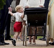 Princas Georgeas žvelgia į vežimėlį, kuriame sesė princesė Charlotte