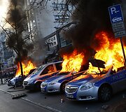 Kovo 18 diena. Frankfurte protestuotojų padegti policijos automobiliai