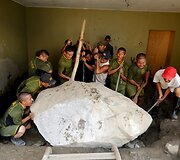 Kovo 26 diena. Savanoriai, keliantys į namą įriedėjusį akmenį po didžiulės žemės nuo&scaron;liaužos Peru