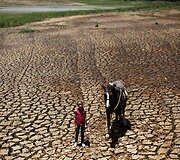 Mergaitė Brazilijoje su savo arkliu prie sausros i&scaron;džiovintos žemės prie užtvankos
