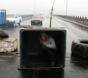 Protestuotojas Čilėje slepiasi nuo lietaus kelio barikadoje
