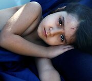 Pabėgėlių mergaitė ilsisi gelbėtojų valtyje netoli Libijos krantų