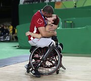 Kanados parolimietė Jamey Jewells neįgaliojo vežymėlyje bučiuoja savo vyrą parolimpietį Adamą Lancia