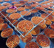 Kinijoje ant stogų džiovinami persimonai