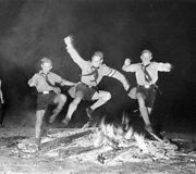 Berniukai &scaron;okinėja per laužą vasaros saulėgrįžos &scaron;ventėje 1937m.