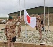 Goro provincijos atkūrimo grupės stovykloje nuleistos misiją baigiančių Japonijos ir Europos Sąjungos vėliavos