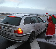 Pakeleivingais automobiliais važiuojantis Kalėdų Senis