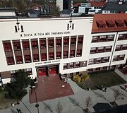FASADAS. Vytauto Didžiojo gimnazijos įėjimas, platus, su dvejomis durimis, dekoruotas tamsesnio klinkerio plytomis.