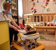 Auklėtoja žaidžia su kūdikiu Mankan Tun vaikų namuose Jerevane