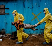 Balandžio 20 diena. Darbinikai ne&scaron;a berniuką, kuris kaip įtariama, užsikrėtęs ebola, į gydymo centrą Liberijoje
