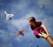 Tėtis laiko mergaitę ant rankų per aitvarų festivalį Kalifornijoje