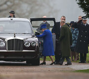 Karalienė Elizabeth II ir princas Philipas lipa į automobilį.