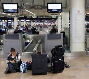 Moteris sėdi ant žemės Zaventem oro uoste