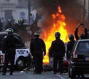 Policininkai stovi netoli degančio automobilio