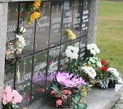 Prie kolumbariumo uždegtos žvakutės.