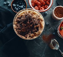 Sluoksniuotas desertas su šviežiomis uogomis, maskarponės kremu ir karamelizuotais trupiniais