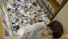 Po žemės drebėjimo Japonijoje bibliotekos darbuotoja deda knygas atgal į lentynas