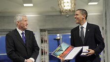 Barackas Obama atsiėmė Nobelio taikos premiją i&scaron; Norvegijos Nobelio komiteto komiteto pirmininko Thorbjoerno Jaglando rankų.