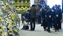 Gedintieji prie memorialo Pietų Korėjoje nuskendusio kelto Sewol aukoms
