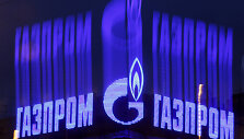 The company logo of Russian natural gas producer Gazprom is seen on an advertisement installed on the roof of a building in St. Petersburg in this November 14, 2013 file photo. As bankers, traders and investors gathered at Gazprom's London offices for its annual champagne reception, the message from