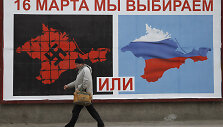 A man walks past a poster calling people to vote in a referendum in the Crimean city of Sevastopol March 16, 2014. Residents of the Crimean penisular prepared to vote in a referendum on Sunday that is widely expected to transfer control of the Black Sea region from Ukraine to Moscow, despite an outc