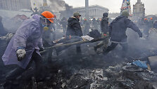 Anti-government protesters carry an injured man on a stretcher after clashes with riot police in the Independence Square in Kiev February 20, 2014. Ukrainian protesters hurling petrol bombs and paving stones drove riot police from the central square in Kiev on Thursday despite a "truce" which embatt