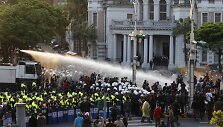 Taivano policija pirmadienį panaudojo vandens patranką, kad i&scaron;varytų &scaron;imtus demonstrantų, įsiveržusių į vyriausybės būstinę