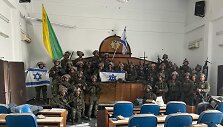 Izraelio pajėgų Golani brigados kariai pozuoja nuotraukai užimtame parlamento pastate Gazos mieste