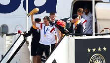 Philippas Lahmas lipa i&scaron; lėktuvo laikydamas rankoje pasaulio futbolo čempionų trofėjų.