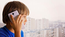 Vaikas kalba telefonu.