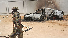 Somalio karys prie sudegusio automobilio