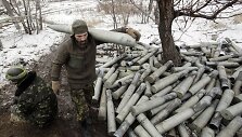Ukrainos karys eina &scaron;alia krūvos panaudotų artilerijos sviedinių tūtų.