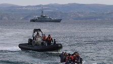 Graikijos pakrantės apsaugos laivai prie valties su migrantais
