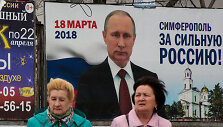 Rusės prie Vladimiro Putino plakato
