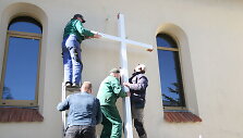Prie bažnyčios tvirtinamas kryžius