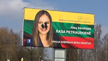Rasos Petrauskienės veidas agitaciniame plakate buvo apipiltas juodais daržais.