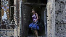 Mergina su savo daiktais i&scaron;eina i&scaron; Donecke ap&scaron;audyto daugiabučio