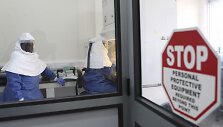 Gydytojai dirba su surinktais Ebola viruso mėginiais.