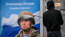 Maskvoje valomas propagandinis plakatas su kariu ir užra&scaron;u &bdquo;&Scaron;lovė Rusijos didvyriams&ldquo;