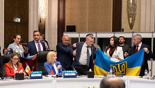 Ukrainos delegacijos nariai i&scaron;skleidžia savo &scaron;alies vėliavą &scaron;alia Rusijos delegacijos vadovės pavaduotojos Olgos Timofejevos
